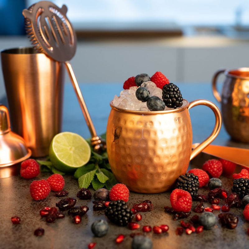 Kupferbecher Set mit Beeren und Zitrusfrüchten und Eiswürfeln